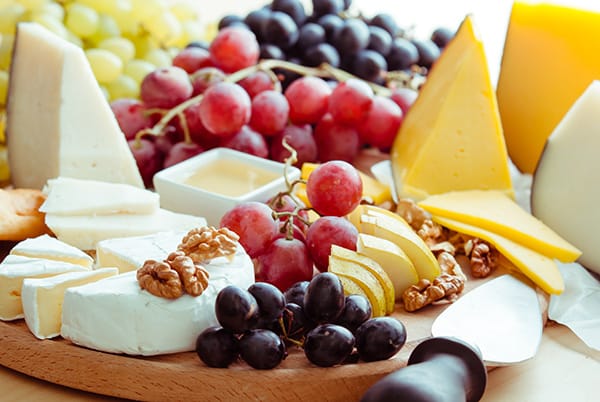 cheese board with grape Picture of young family playning football on a beach
