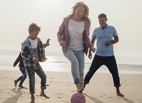 family-winter Family activities - running and playing ball on beach