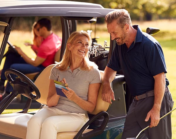 Mature And Mid Adult Couples In Buggies Playing Round On Golf Together Best golf courses and golf packages Northland