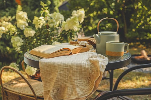 Quiet garden setting at Treghan Lodge with a small table, book and tea in soft natural light