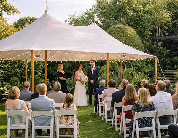 Intimate garden wedding ceremony set on Treghan lawn with a sailcloth marquee, surrounded by mature gardens and seating for wedding guests. Intimate garden wedding ceremony set on Treghan lawn with a sailcloth marquee, surrounded by mature gardens and seating for wedding guests.