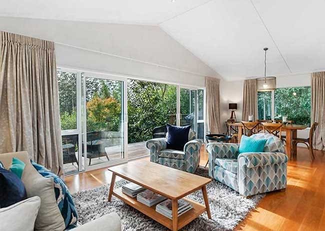 Spacious living area with open deck at Birdsong Retreat Treghan Lodge Kerikeri