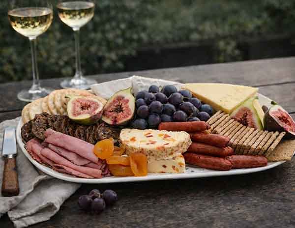 Gourmet welcome platter with local wine on a private garden deck at Treghan Lodge, Bay of Islands