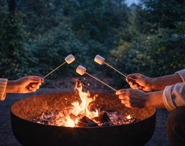 Toasting marshmallows beside the outdoor firepit during a winter stay at Treghan Lodge