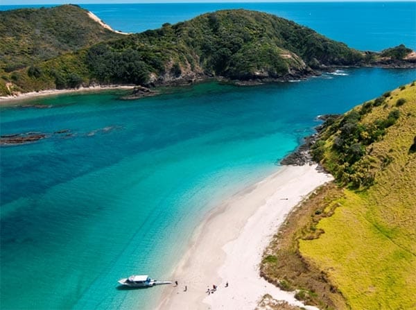Aerial view of a cruise boat at a remote Bay of Islands beach