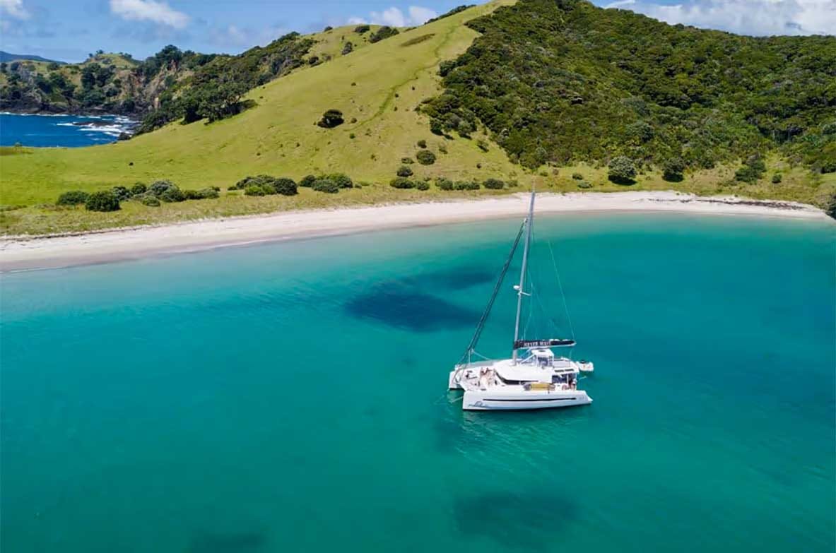 Catamaran cruising the turquoise waters of the Bay of Islands Catamaran cruising the turquoise waters of the Bay of Islands