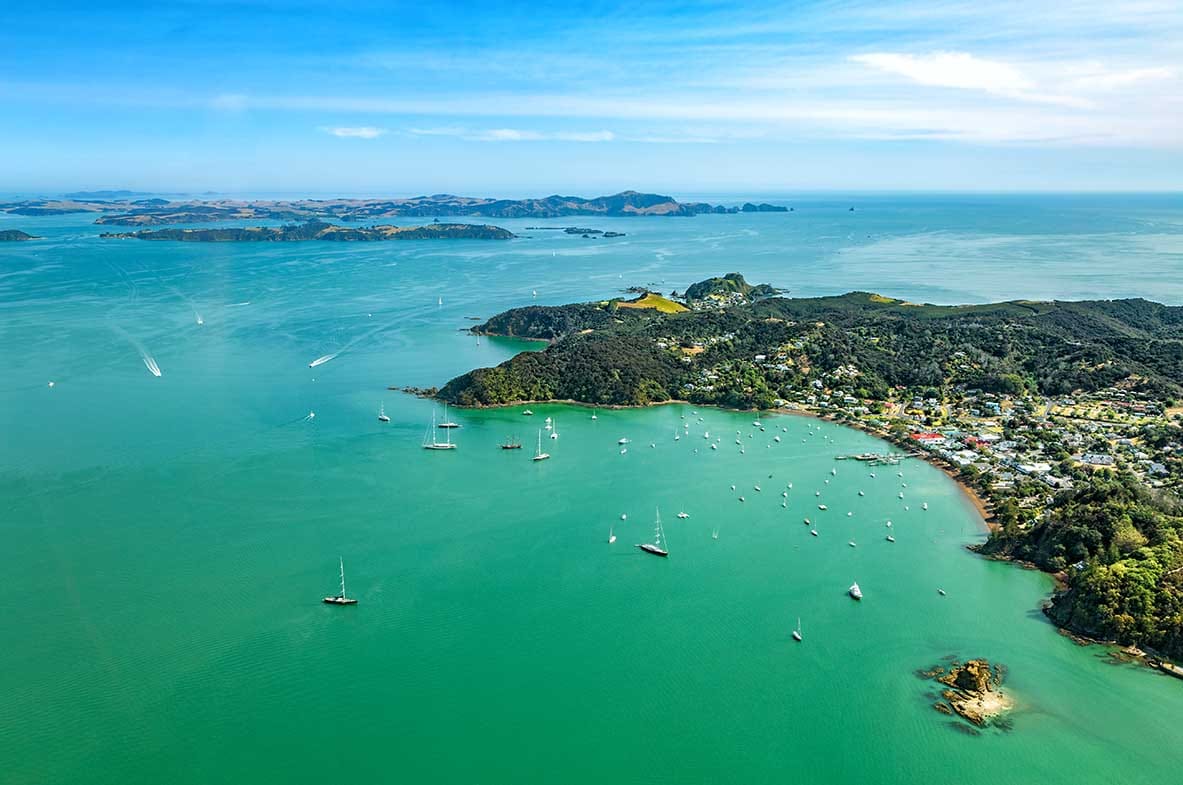 Peaceful Russell waterfront in the Bay of Islands with pōhutukawa trees, boats and historic wharf. Peaceful Russell waterfront in the Bay of Islands with pōhutukawa trees, boats and historic wharf.